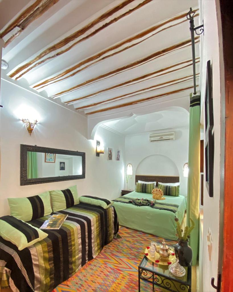 une chambre avec deux lits et un canapé dans l'établissement Dar Soukaina, à Marrakech