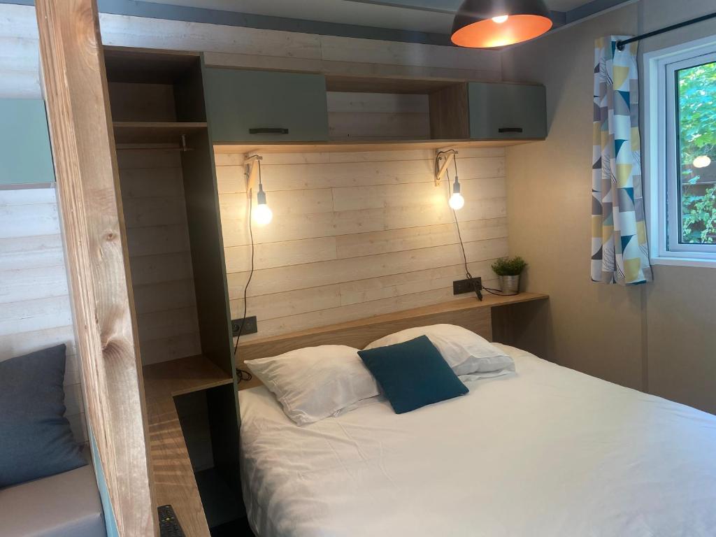 une chambre avec un lit avec une tête de lit en bois dans l'établissement Camping Frédéric Mistral, à Castellane 37 autres photos
