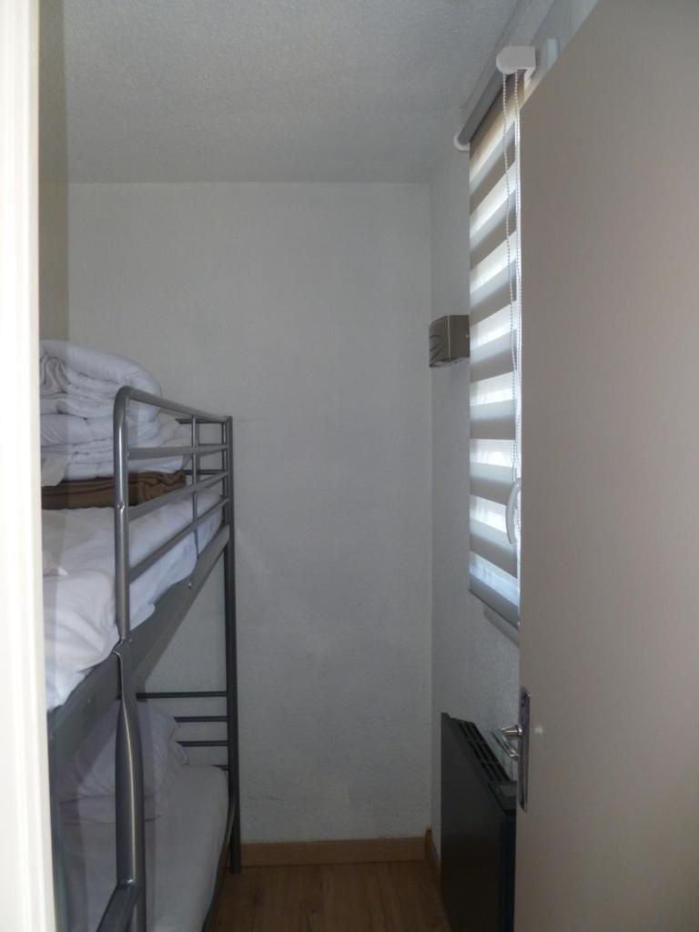 une chambre avec un lit superposé et une fenêtre dans l'établissement Risoul 1850 appartement 4 personnes proches pistes., à Risoul