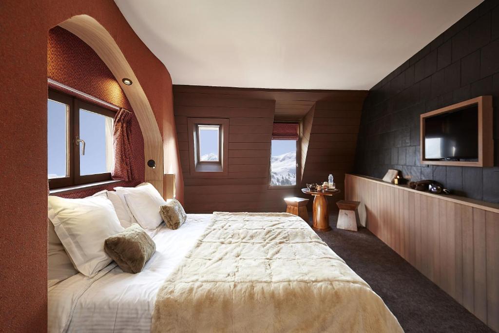 une chambre avec un grand lit dans une pièce dans l'établissement Hôtel des Dromonts by SOWELL COLLECTION, à Avoriaz