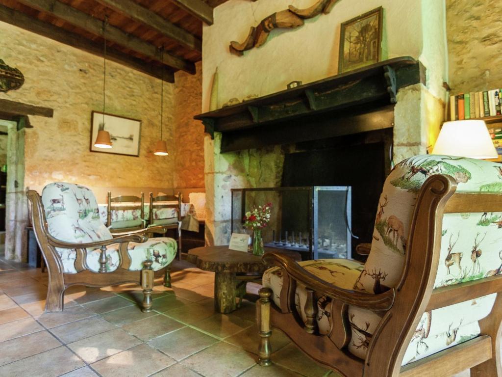 un salon avec deux chaises et une cheminée dans l'établissement Estate in Dordogne near Sites, à Falcou