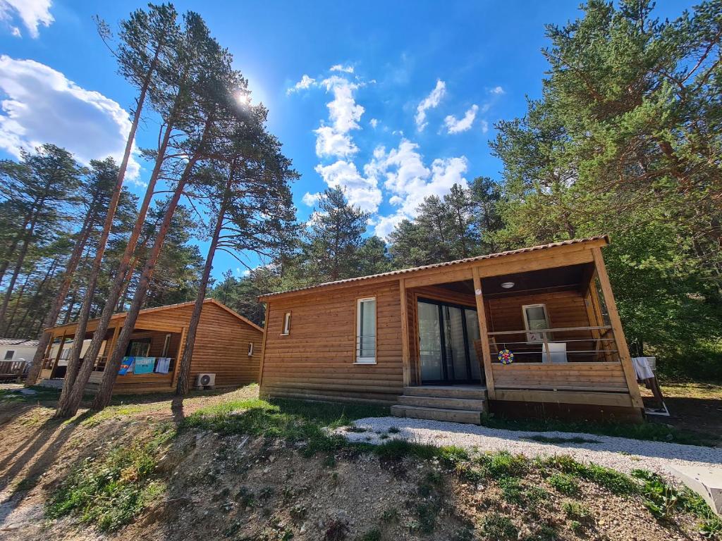 une cabane en rondins entourée d'arbres dans l'établissement Camping La Pinatelle, à Saint-Auban 28 autres photos