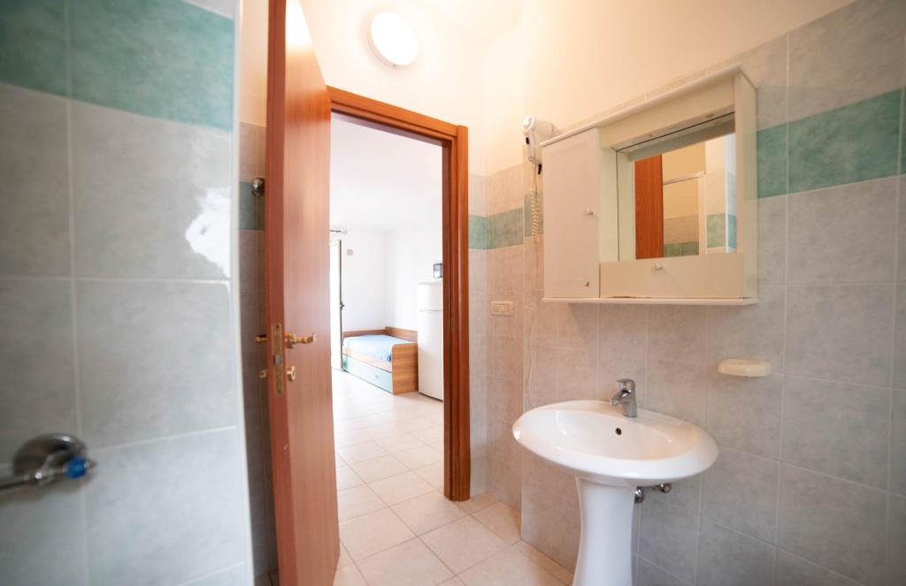 une salle de bain avec un lavabo et un miroir dans l'établissement Residence Il Falco, à Vieste