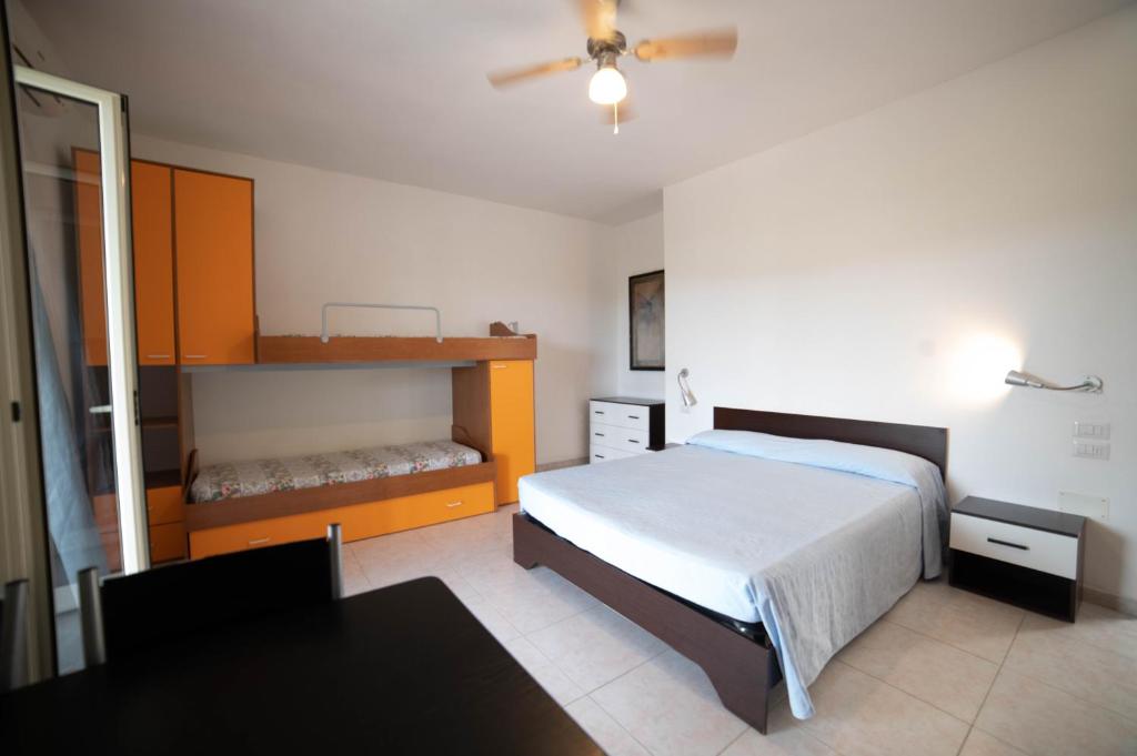 une chambre avec un lit et un bureau et un lit sidx sidx sidx dans l'établissement Residence Il Falco, à Vieste