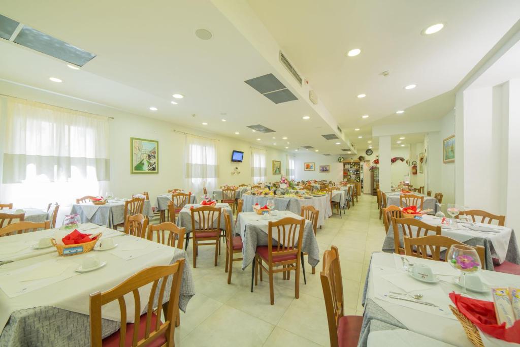 une salle à manger avec des tables et des chaises dans un restaurant dans l'établissement Hotel Venezia, à Caorle