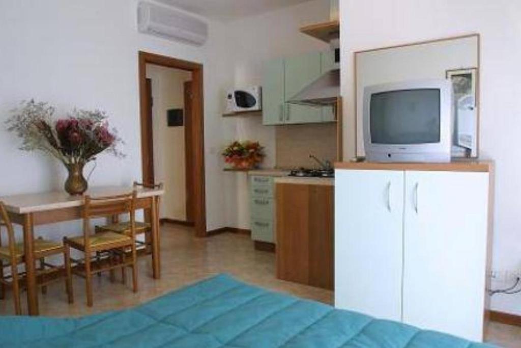 une cuisine et une salle à manger avec une télévision sur une armoire dans l'établissement Residence Mini Sayonara, à Lido di Jesolo