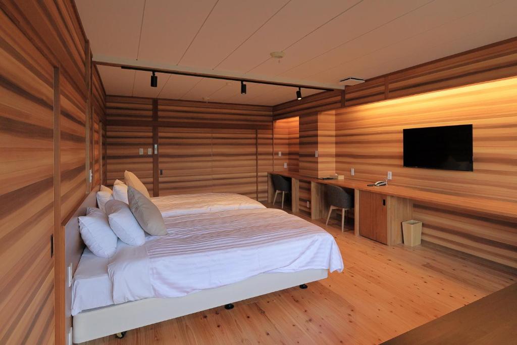 une chambre avec un lit, un bureau et une télévision dans l'établissement mt. inn(マウントイン）, à Nihommatsu