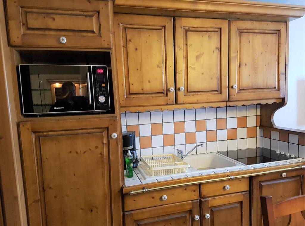 une cuisine avec un micro-ondes et un évier dans l'établissement Premium Les Alpages de Chantel, à Arc 1800