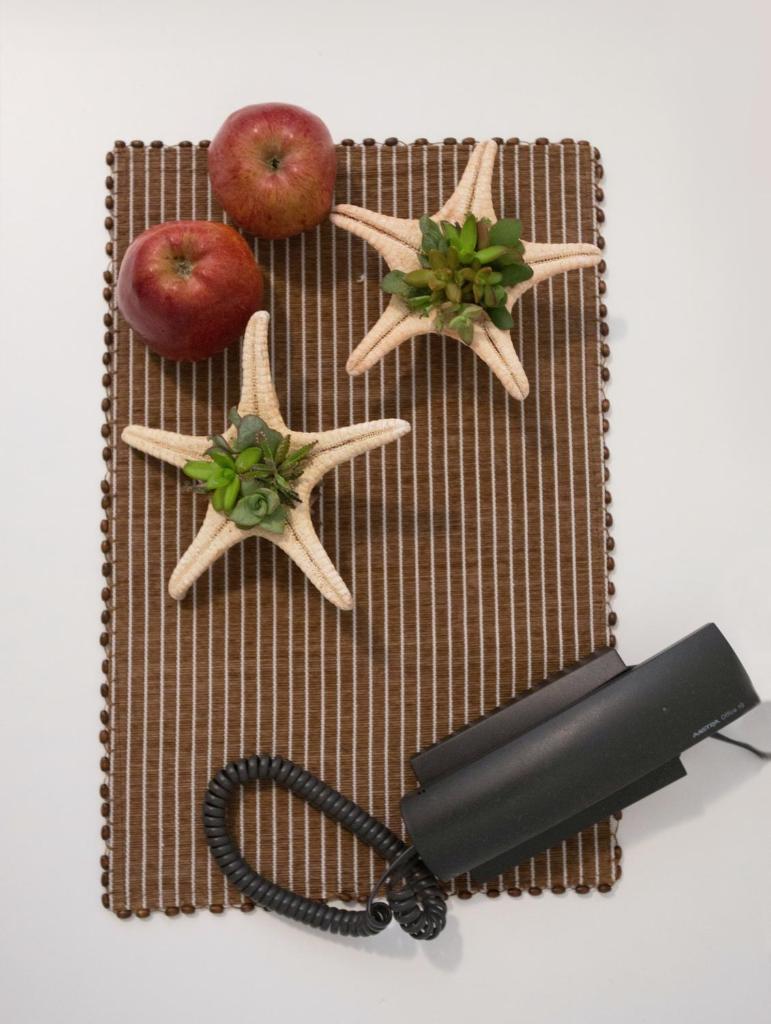 - une table avec deux pommes et un téléphone dans l'établissement Lacroma Aparthotel, à Grado