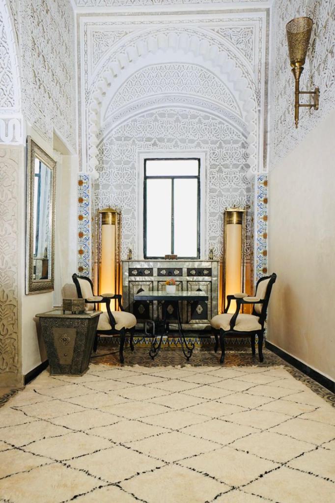 - une chambre avec deux chaises et un piano dans l'établissement Riad Amelia - Lalla Amelia Room, à Tetouan