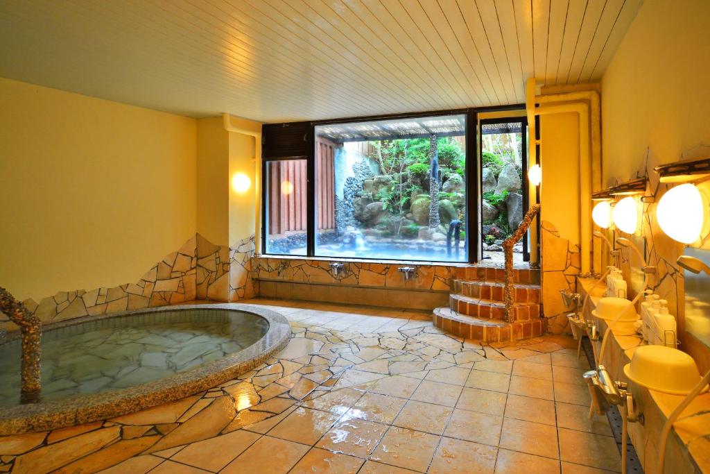 La salle de bains est pourvue d'une baignoire et d'une grande fenêtre. dans l'établissement Inasayama Kanko Hotel, à Nagasaki