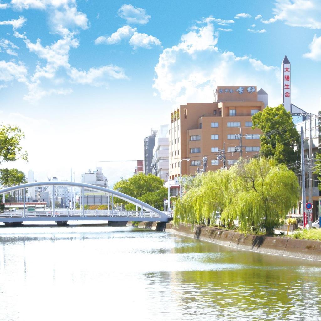 un pont sur une rivière dans une ville dans l'établissement Hotel Takasago, à Kōchi
