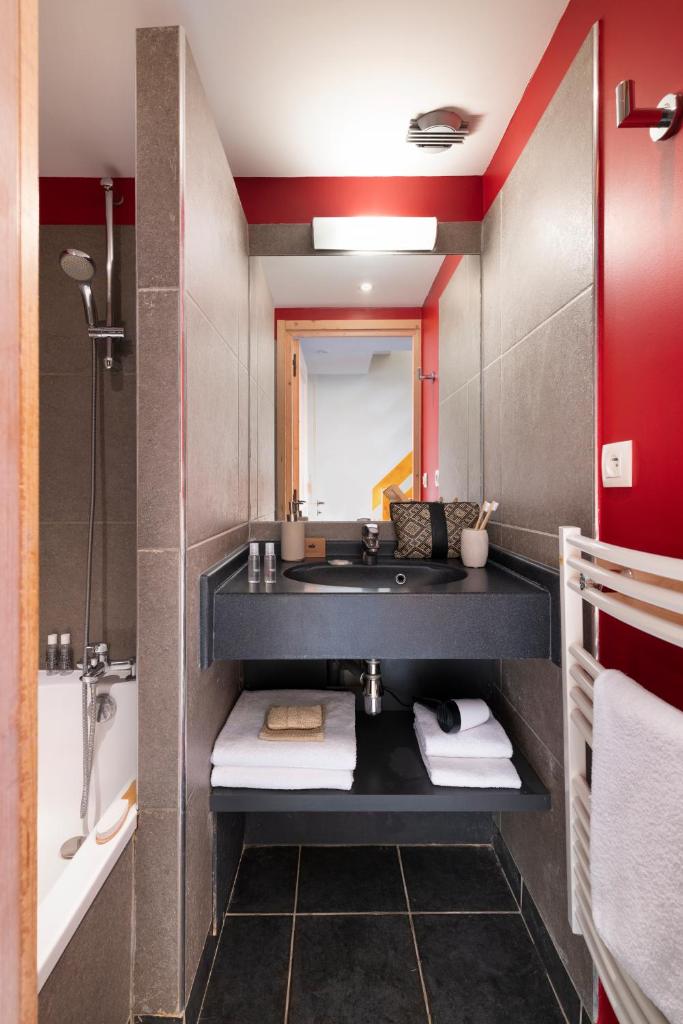 une salle de bain avec un lavabo et une baignoire dans l'établissement Résidence Pierre & Vacances Premium les Crets, à Les Allues