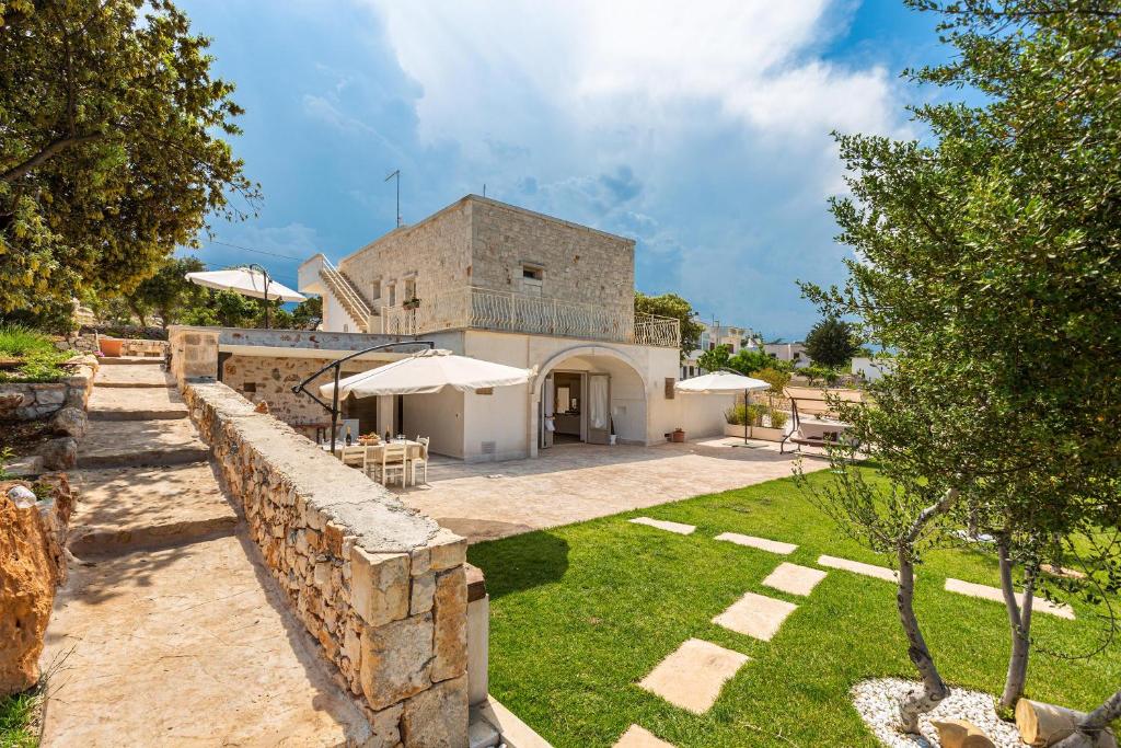 - une vue extérieure sur un bâtiment avec un mur en pierre dans l'établissement Casa Marangi by BarbarHouse, à Ostuni