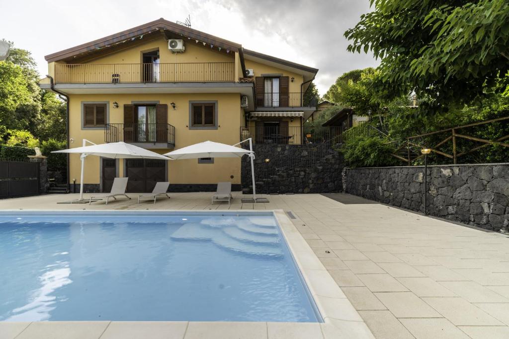 une villa avec piscine devant une maison dans l'établissement Villa Sara sull'etna con Piscina, à Viagrande