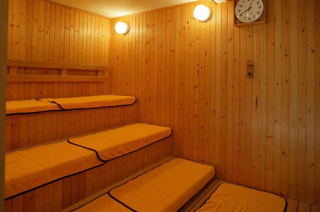 un sauna avec deux étagères et une horloge au mur dans l'établissement Hirayunomori, à Takayama