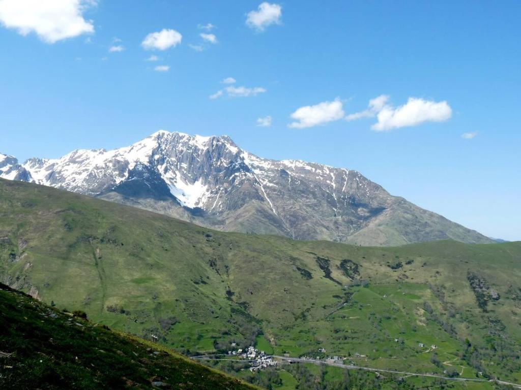 Une montagne enneigée avec une ville en face dans l'établissement Coquet appartement 5 places labélisé tout équipé, à Saint-Lary-Soulan