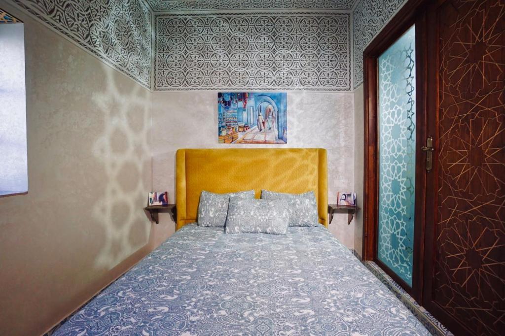 une chambre avec un lit avec une tête de lit en bois dans l'établissement Riad Amelia : Lalla Fatima Zohra Room, à Tetouan
