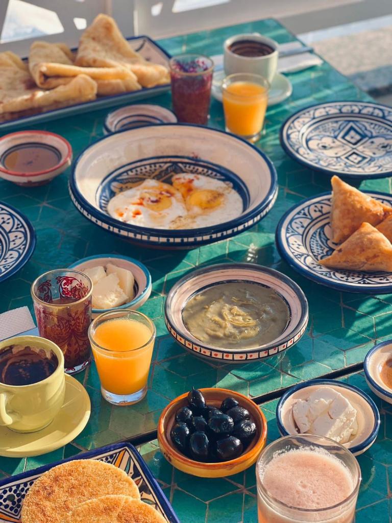 une table garnie d'assiettes de nourriture et de boissons dans l'établissement Riad Amelia : Lalla Fatima Zohra Room, à Tetouan