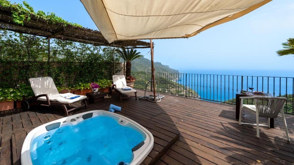- un bain à remous sur une terrasse avec un parasol dans l'établissement VILLA CASAROSSA NUMERO UNO 6, Emma Villas, à Ravello