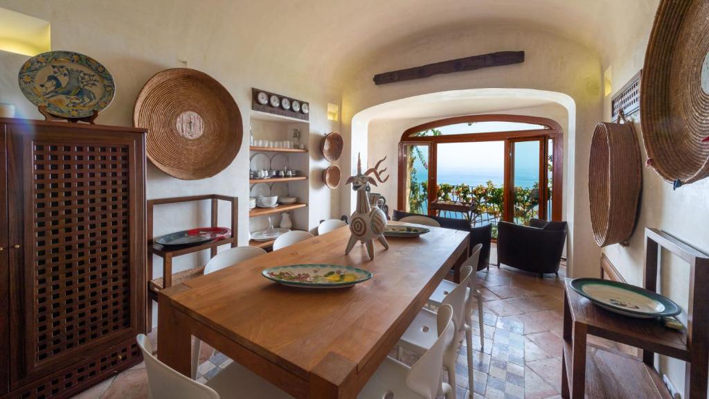 une salle à manger avec une table et des chaises en bois dans l'établissement VILLA CASAROSSA NUMERO UNO 6, Emma Villas, à Ravello