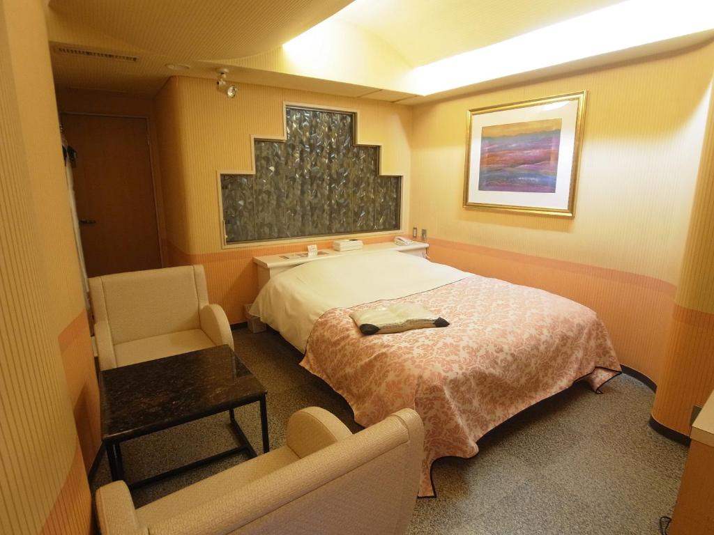 une chambre avec un lit, un canapé et une chaise dans l'établissement Hotel Mju-Adult Only, à Tokyo