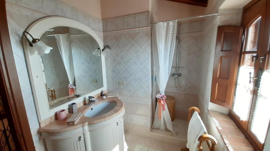 une salle de bain avec un lavabo, un miroir et une douche dans l'établissement Villa Armonia, à Borgo a Mozzano