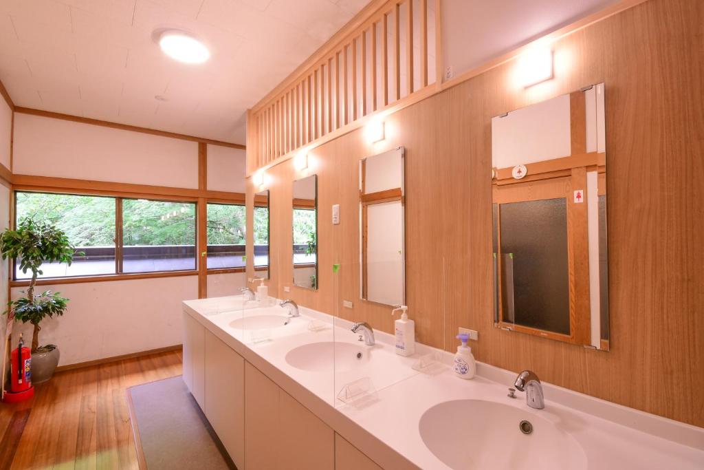 une salle de bain avec trois lavabos et deux miroirs dans l'établissement 高野山 宿坊 増福院 -Koyasan Shukubo Zofukuin-, à Koyasan