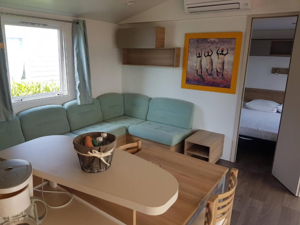 un salon avec un canapé et une table dans l'établissement Frejus tout confort, climatisation,plus ventilation toutes les chambres, linge de lit et de toilette , coffre fort, lavé vaisselle machine à laver grande terrasse couverte velos et wifi possible, à Fréjus