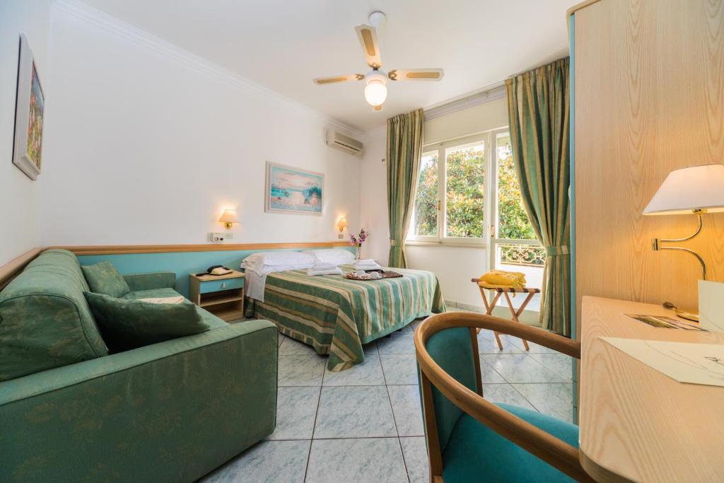 une chambre d'hôtel avec un canapé et un lit dans l'établissement Hotel Bamby, à Cervia