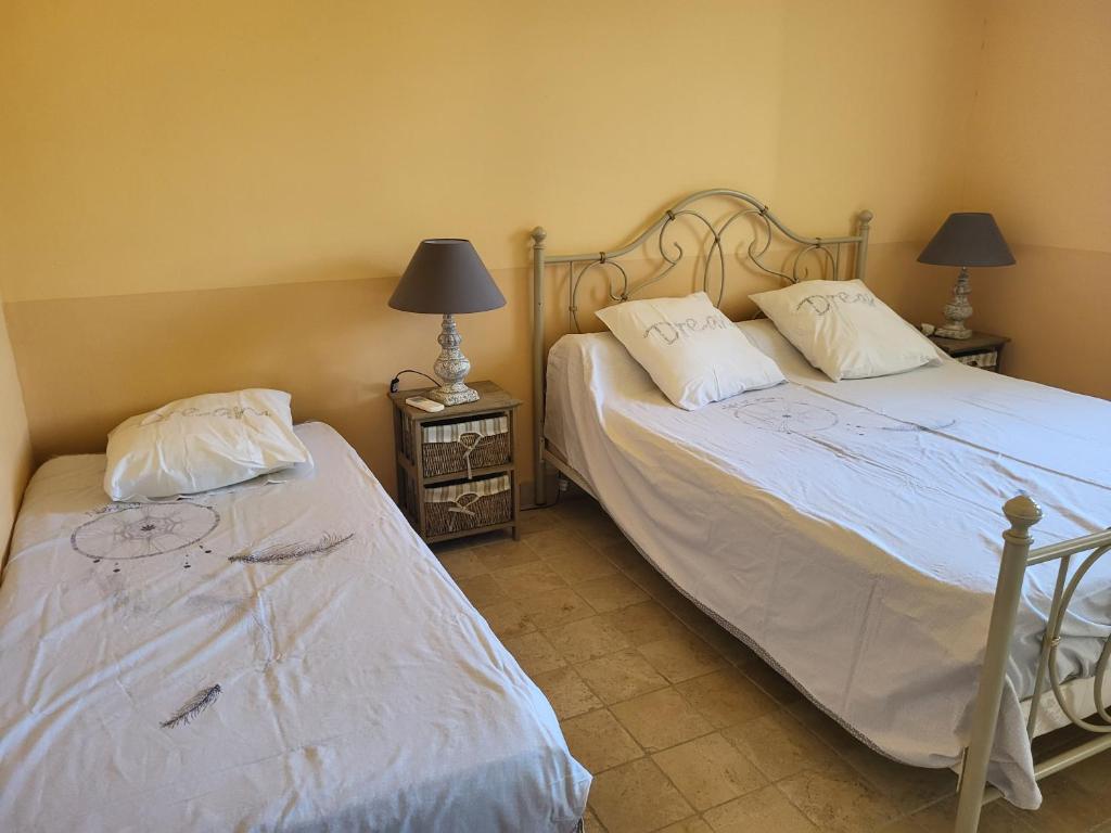 deux lits côte à côte dans une chambre dans l'établissement Gitedelea, à Aubignan