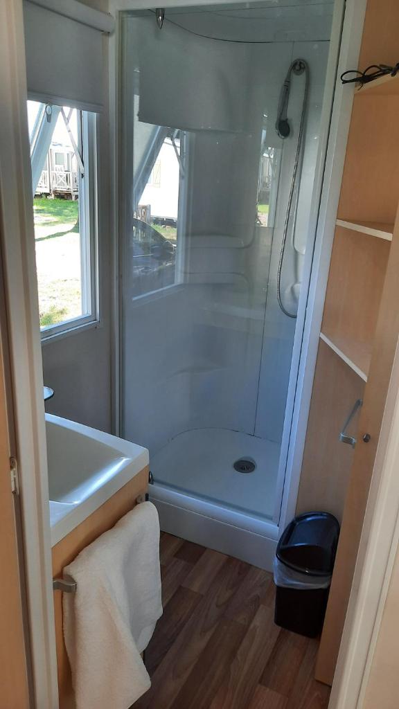 La salle de bains est pourvue d'une douche et d'un lavabo blanc. dans l'établissement Le Ried Camping To hapi, à Boofzheim