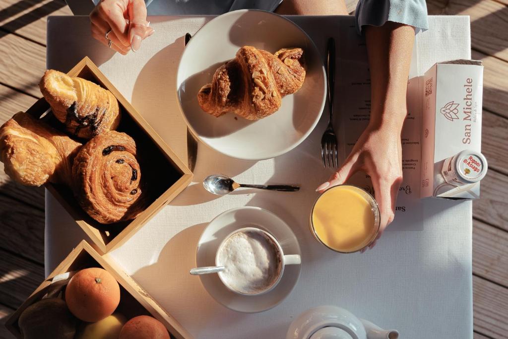 une table avec une boîte de pain et une assiette de nourriture dans l'établissement San Michele Relais & Spa, à Sirolo