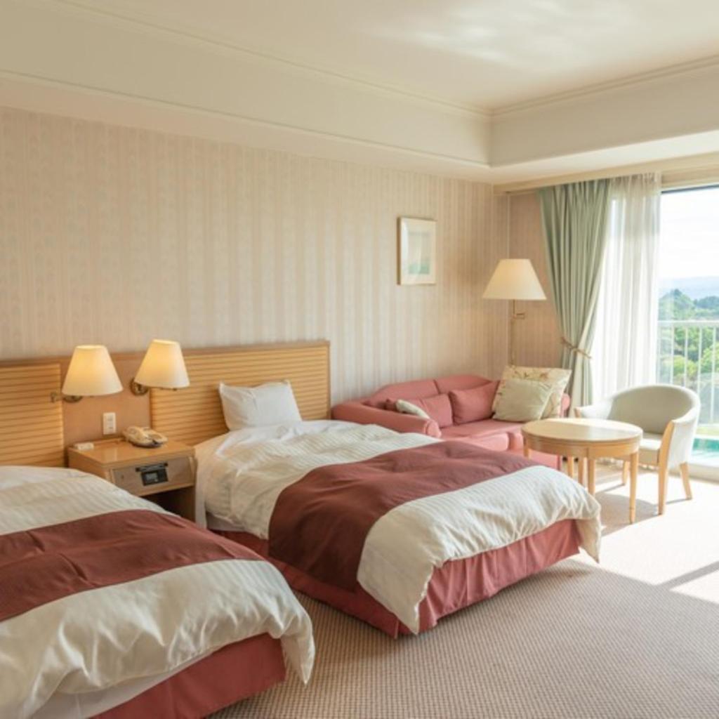 une chambre d'hôtel avec deux lits et un canapé dans l'établissement Onahama Ocean Hotel & Golf Club, à Iwaki 37 autres photos