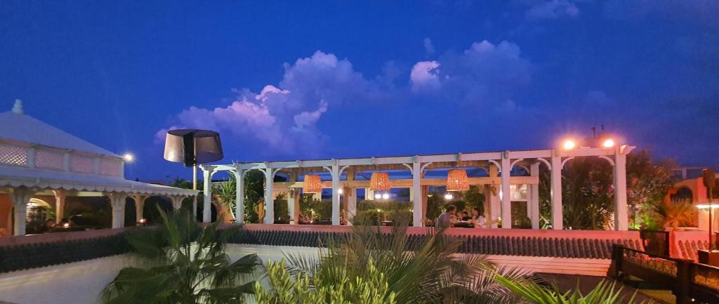 - un bâtiment éclairé avec piscine la nuit dans l'établissement Riad Monceau, à Marrakech