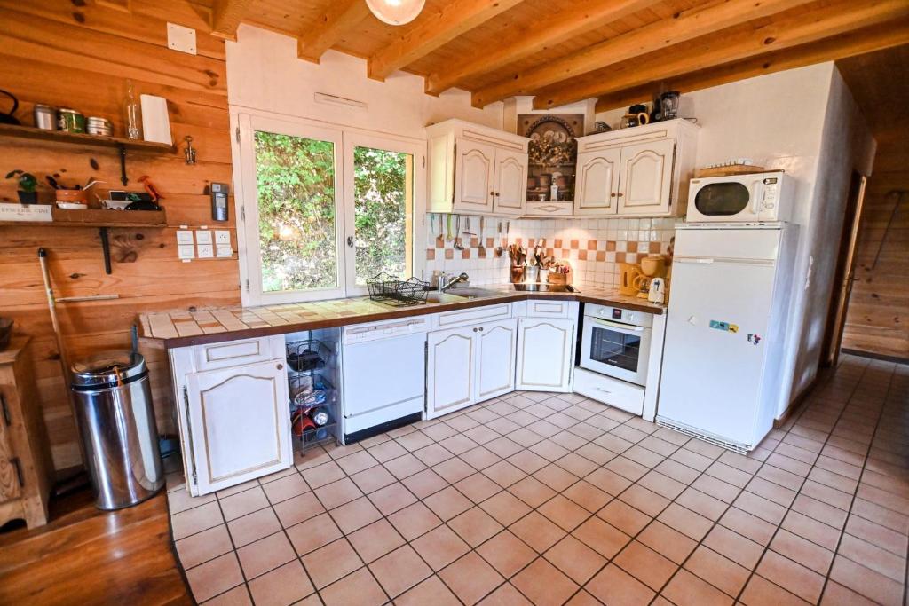 Il comprend une cuisine avec des appareils électroménagers blancs et du carrelage. dans l'établissement Chalet paisible de 170m avec jolie TERRASSE !, à Saint-Gervais-les-Bains 13 autres photos