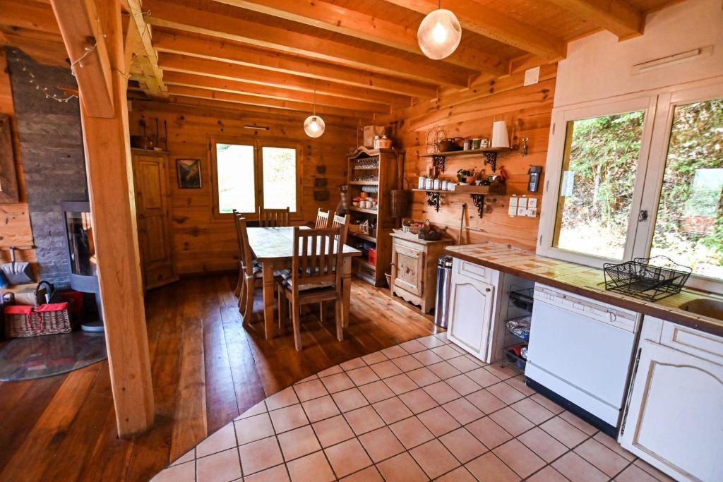 une cuisine et une salle à manger avec une table dans une cabine dans l'établissement Chalet paisible de 170m avec jolie TERRASSE !, à Saint-Gervais-les-Bains