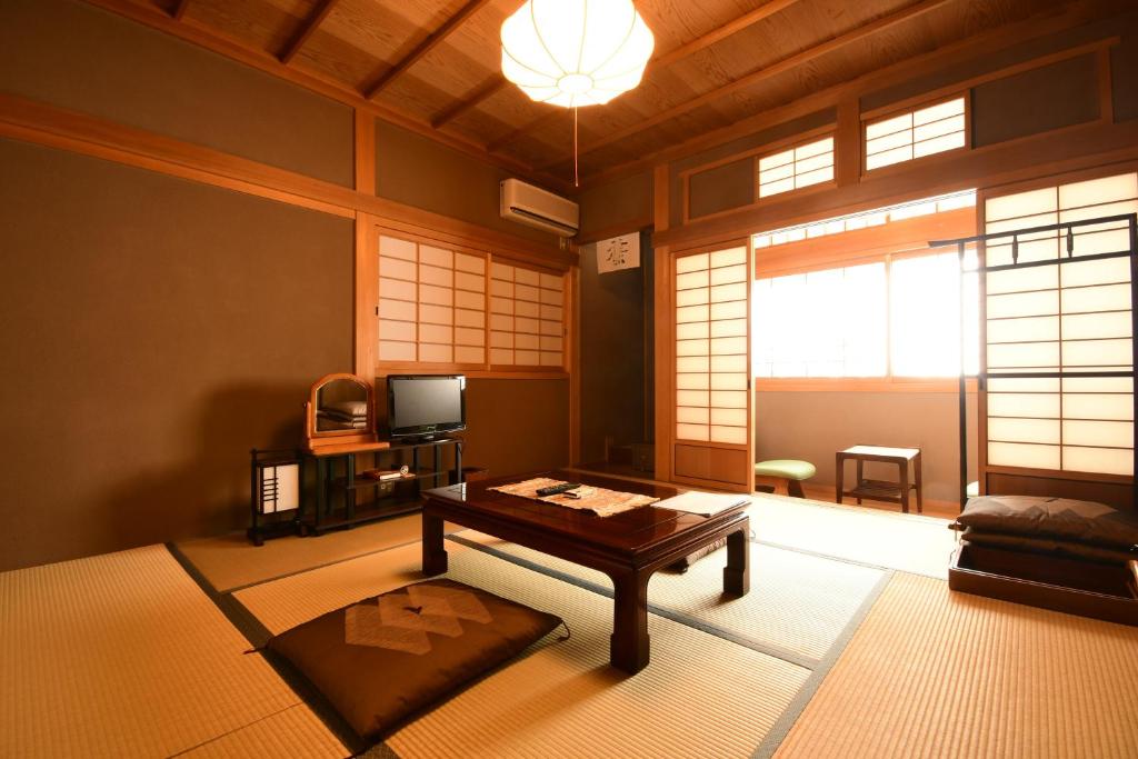 un salon avec une table et une télévision dans l'établissement 高野山 宿坊 龍泉院 -Koyasan Shukubo Ryusenin-, à Koyasan