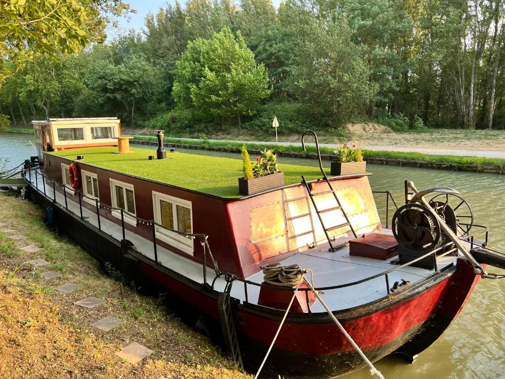 un bateau est amarré dans l'eau dans l'établissement Péniche Dondon - Gîte cocooning sur Canal du midi, à Avignonet-de-Lauragais