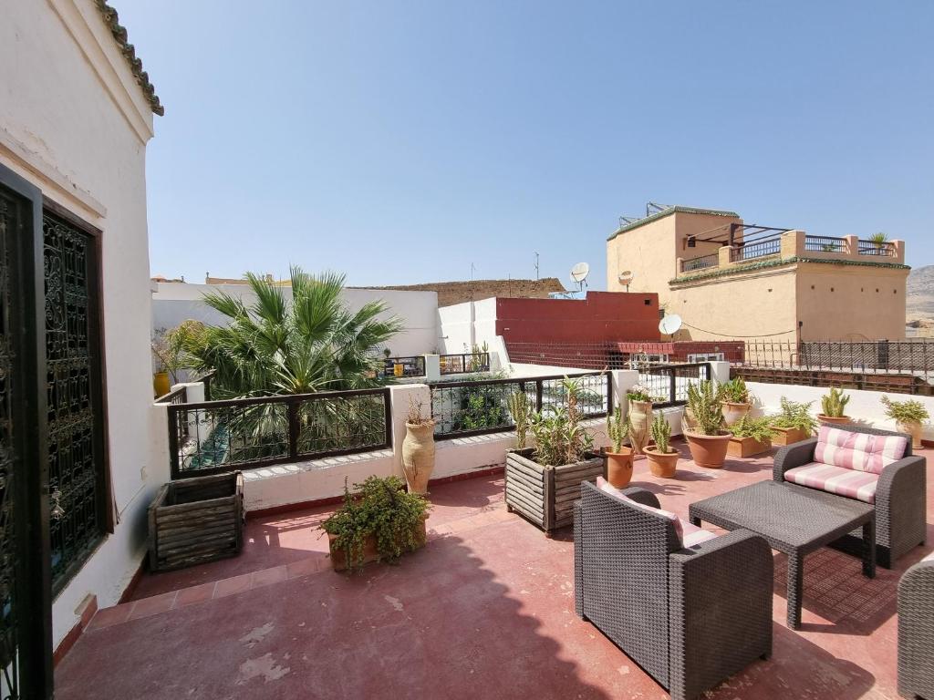 un patio avec des chaises et une table sur un balcon dans l'établissement Riad Le Sucrier de Fès, à Fès
