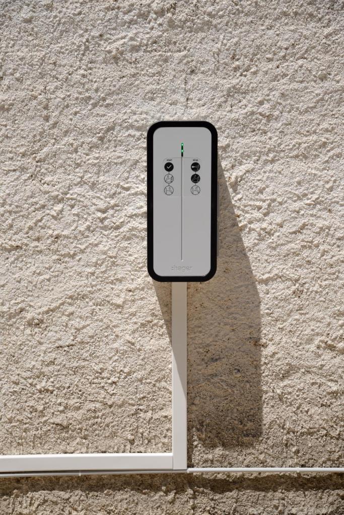 un panneau de téléphone portable sur le côté d'une paroi dans l'établissement Le Pool House - Private Jacuzzi - Mas des Sous Bois, à Ventabren