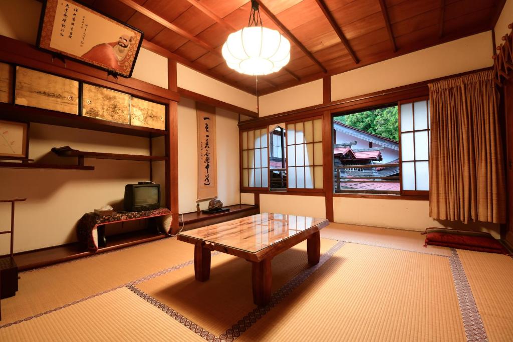 un salon avec une table en bois et une télévision dans l'établissement 高野山 宿坊 大明王院 -Koyasan Shukubo Daimyououin-, à Koyasan