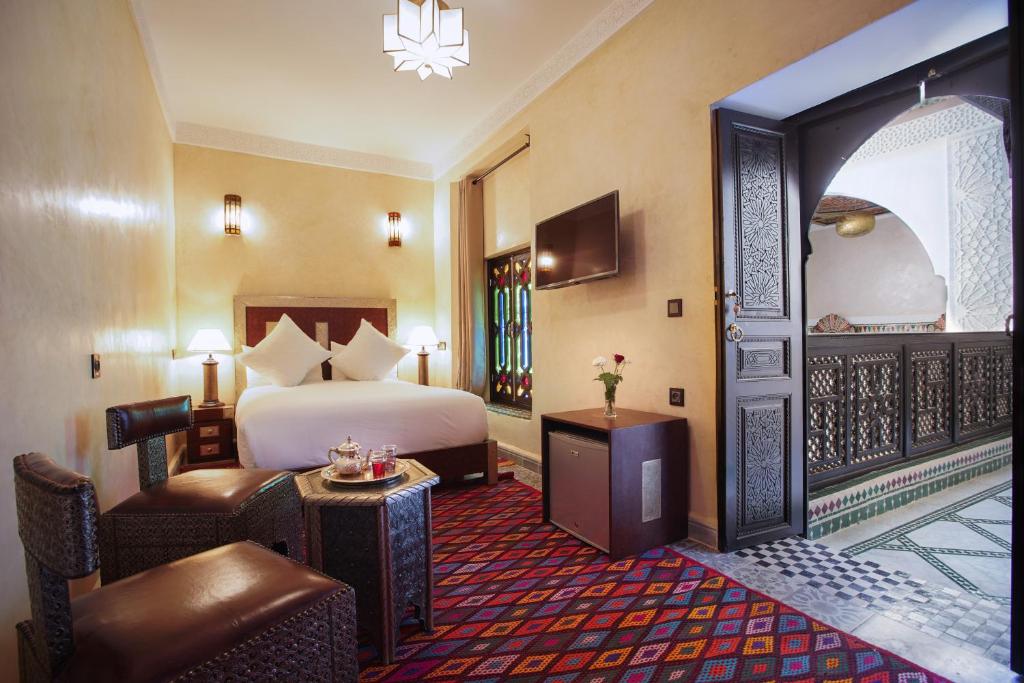 une chambre d'hôtel avec un lit et un coin salon dans l'établissement Riad Mazaj, à Marrakech