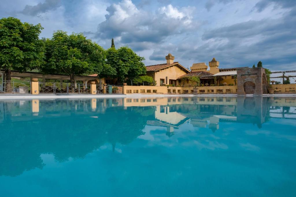une piscine d'eau en face d'un bâtiment dans l'établissement FIRENZE Villa a 5 Stelle - Villa Gaudia Luxury & Relax in Chianti, à Florence