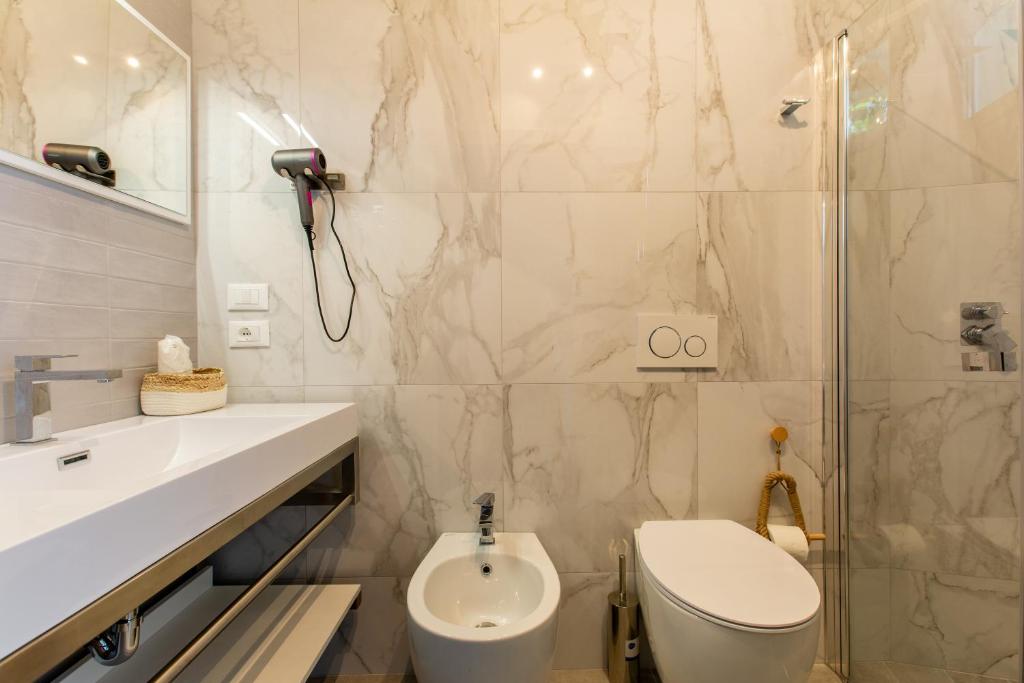 une salle de bain avec toilettes, lavabo et douche dans l'établissement Hotel Jole, à San Mauro a Mare