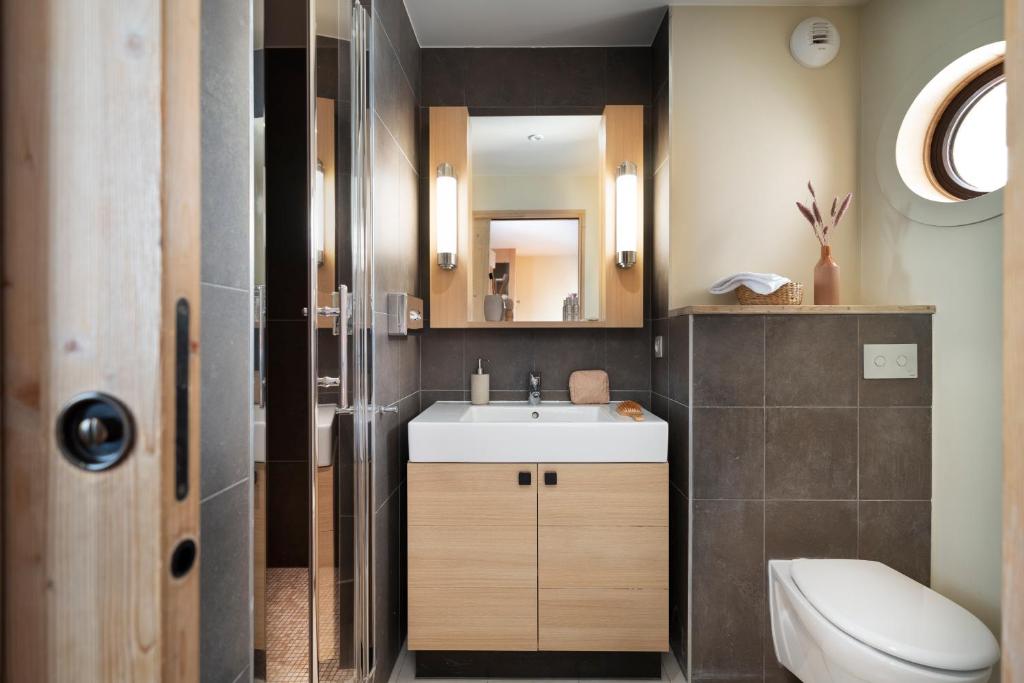 une salle de bain avec un lavabo, des toilettes et un miroir dans l'établissement Résidence Pierre & Vacances Premium L'Amara, à Avoriaz