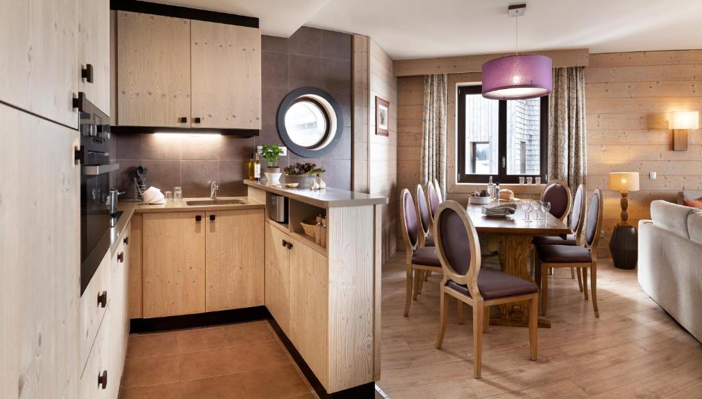 une cuisine et une salle à manger avec une table et des chaises dans l'établissement Résidence Pierre & Vacances Premium L'Amara, à Avoriaz