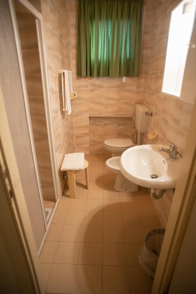 une salle de bain avec un lavabo et des toilettes dans l'établissement Hotel Umberto, à Rosolina Mare