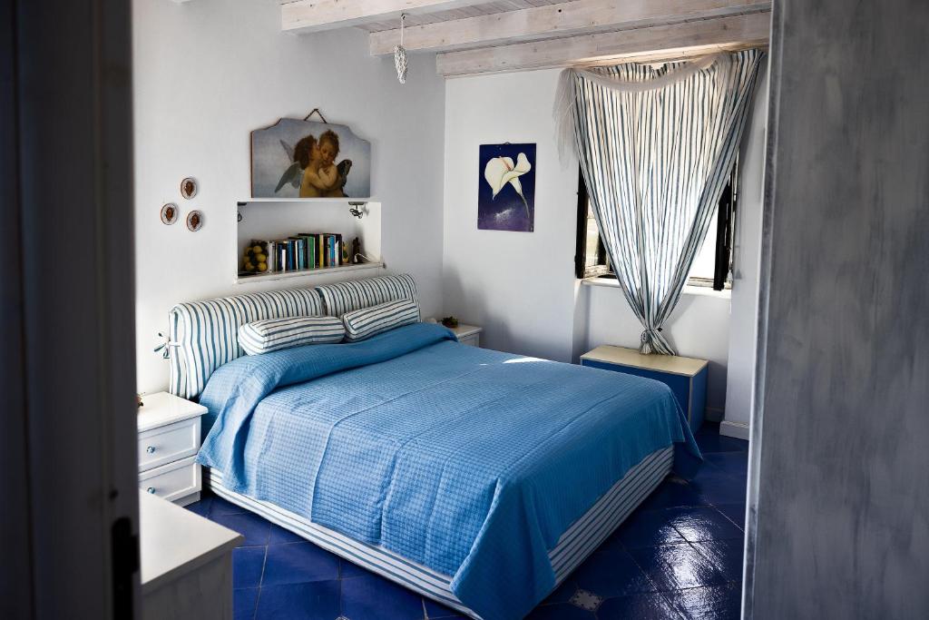 une chambre avec un lit bleu et une fenêtre dans l'établissement Villa Con Piscina Vista Mare, à Santo Stefano 20 autres photos