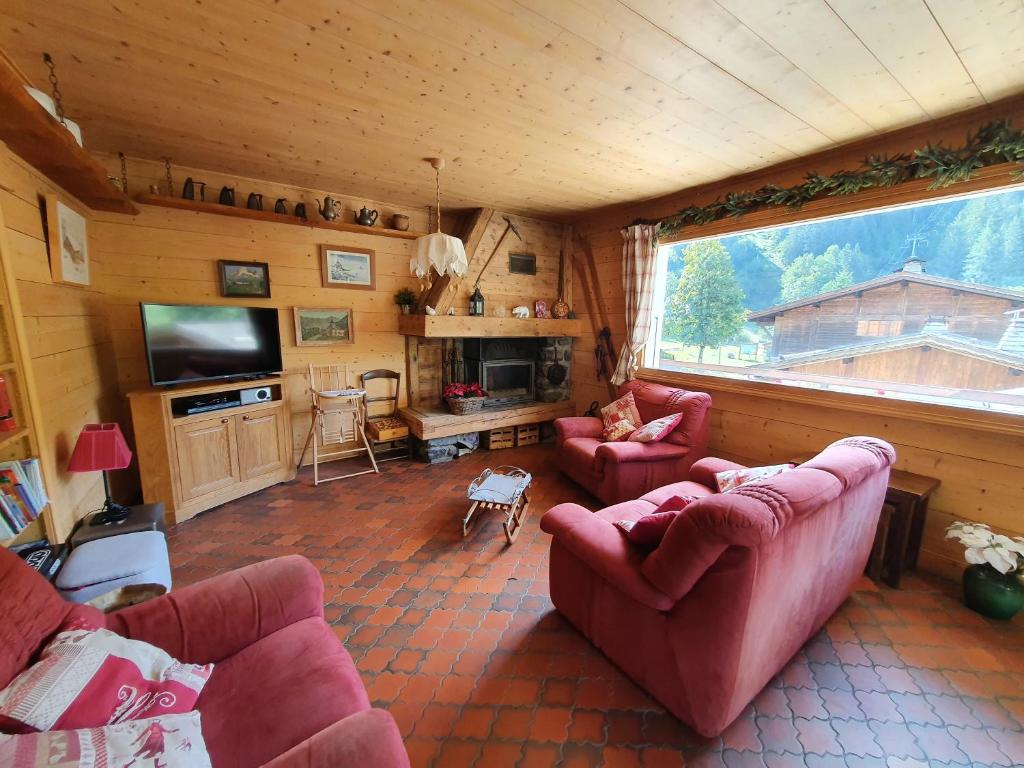 un salon avec deux canapés et une grande fenêtre dans l'établissement Chalet Ramadieu, à La Giettaz